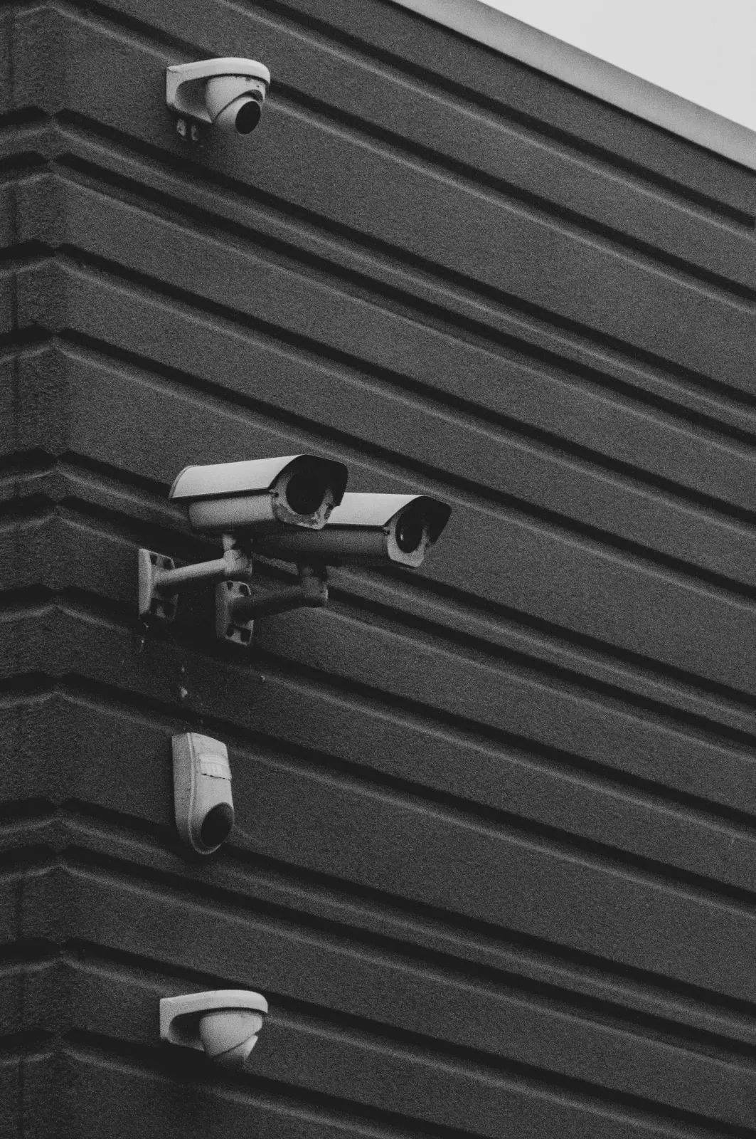 عدة كاميرات مراقبة مثبتة على جدار معدني داكن — كاميرات هيك فيجن