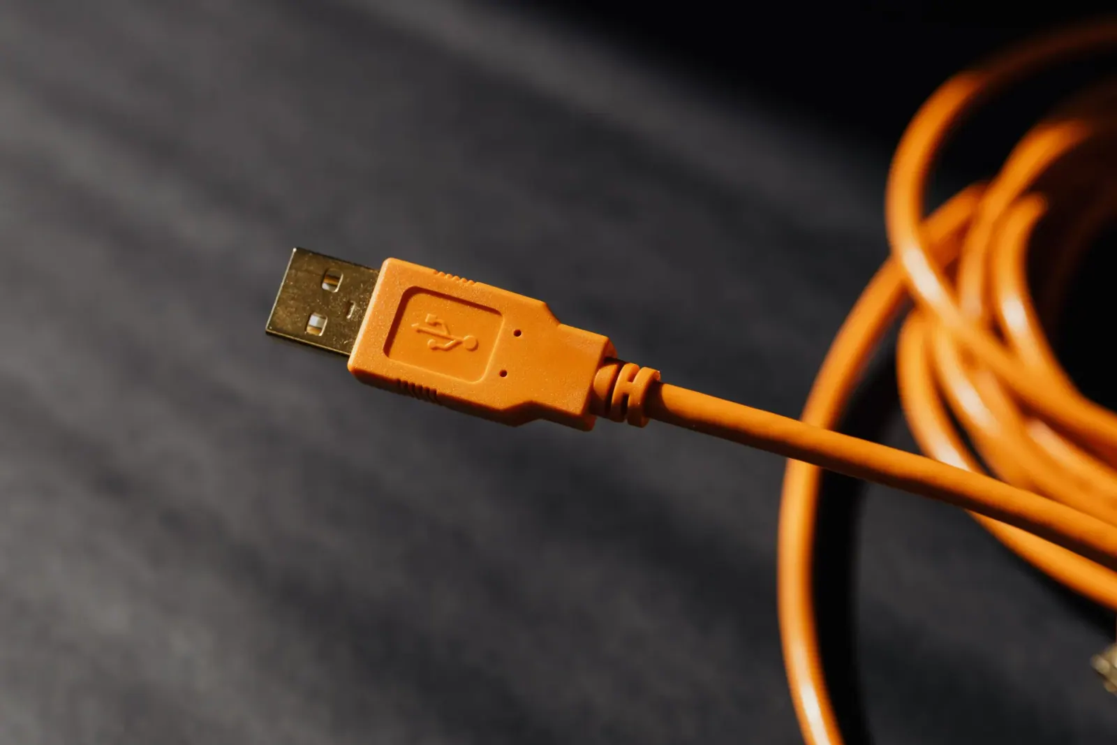 كابل USB برتقالي ملفوف بلقطة قريبة — جودة كابلات التوصيل